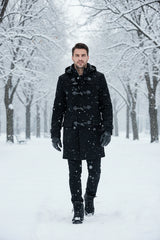 A man wearing a black hooded duffle coat with toggle closures over a white collared shirt, shown against a plain white background.