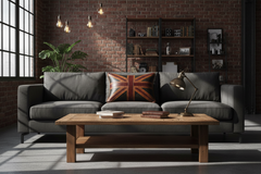 A modern gray fabric sofa in a loft-style living room with a brick wall, a wooden coffee table, and a Union Jack throw pillow.