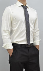 A man wearing a white long-sleeve dress shirt, a dark gray tie, black dress pants, and a black belt, shown from the neck down against a light gray studio background.
