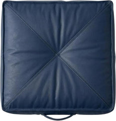 A square navy blue leather or -leather cushion with a diagonal stitched design radiating from the center and a small loop handle at the bottom, shown on a plain white background.