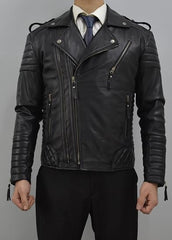 A man wearing a black leather motorcycle jacket with quilted details, zippers, and shoulder epaulets, styled over a white shirt and blue tie.