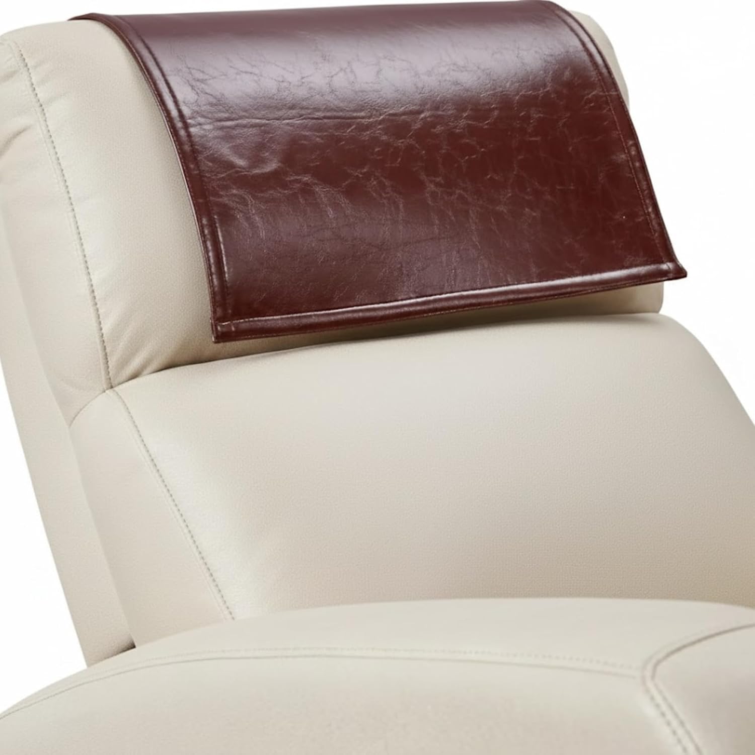A close-up of a cream-colored leather chair with a dark brown faux-leather headrest cover resting on the headrest.