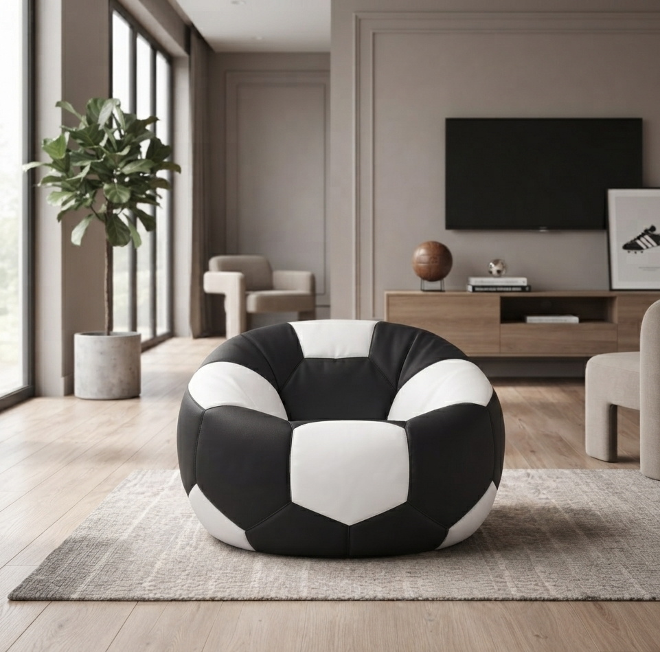 A round bean bag chair designed like a soccer ball, featuring black and white panels, placed on a gray rug in a modern living room setting.