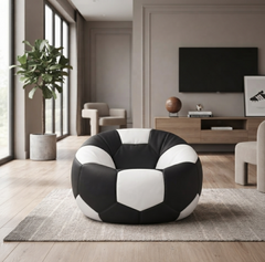 A round bean bag chair designed like a soccer ball, featuring black and white panels, placed on a gray rug in a modern living room setting.