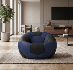 A soccer-ball-shaped bean bag chair in navy blue and black panels, styled in a modern living room setting on a light beige rug.