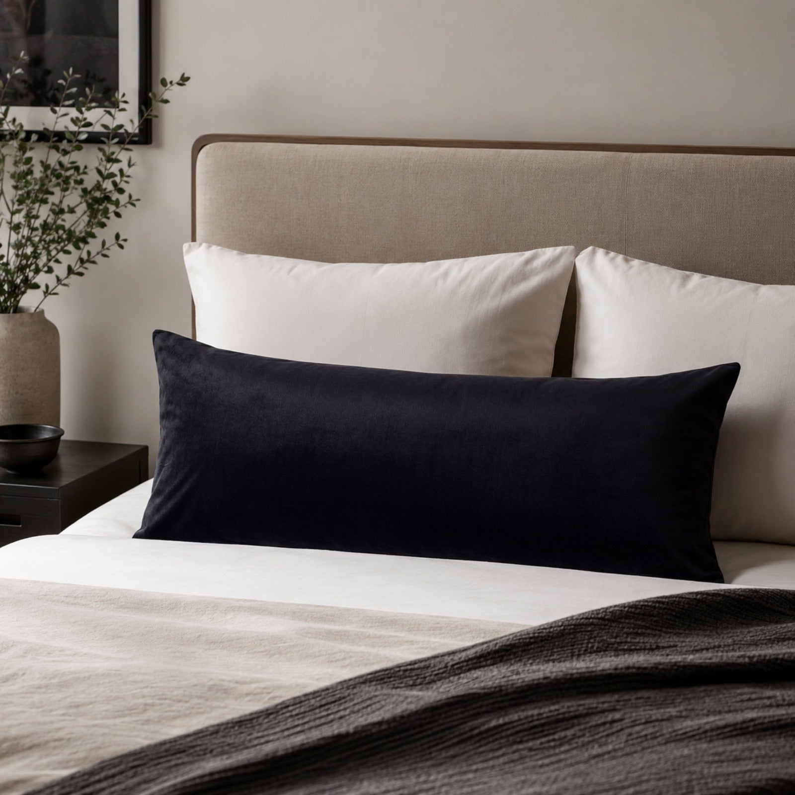 Bed with white and black pillows in a bedroom setting