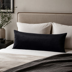 Bed with white and black pillows in a bedroom setting