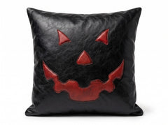 A square black -leather throw pillow featuring a red stitched jack-o'-lantern face design on the front, set against a plain white background.