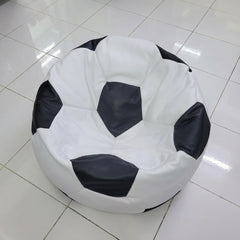A round bean bag chair designed like a soccer ball, featuring a white body with black pentagonal panels, placed on a glossy white tiled floor.