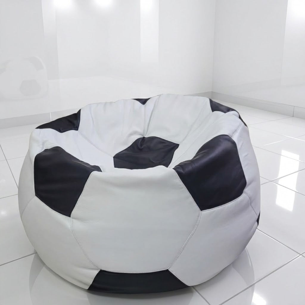 A round bean bag chair designed like a soccer ball, featuring black and white panels, set in a bright, modern white room with tiled floors.