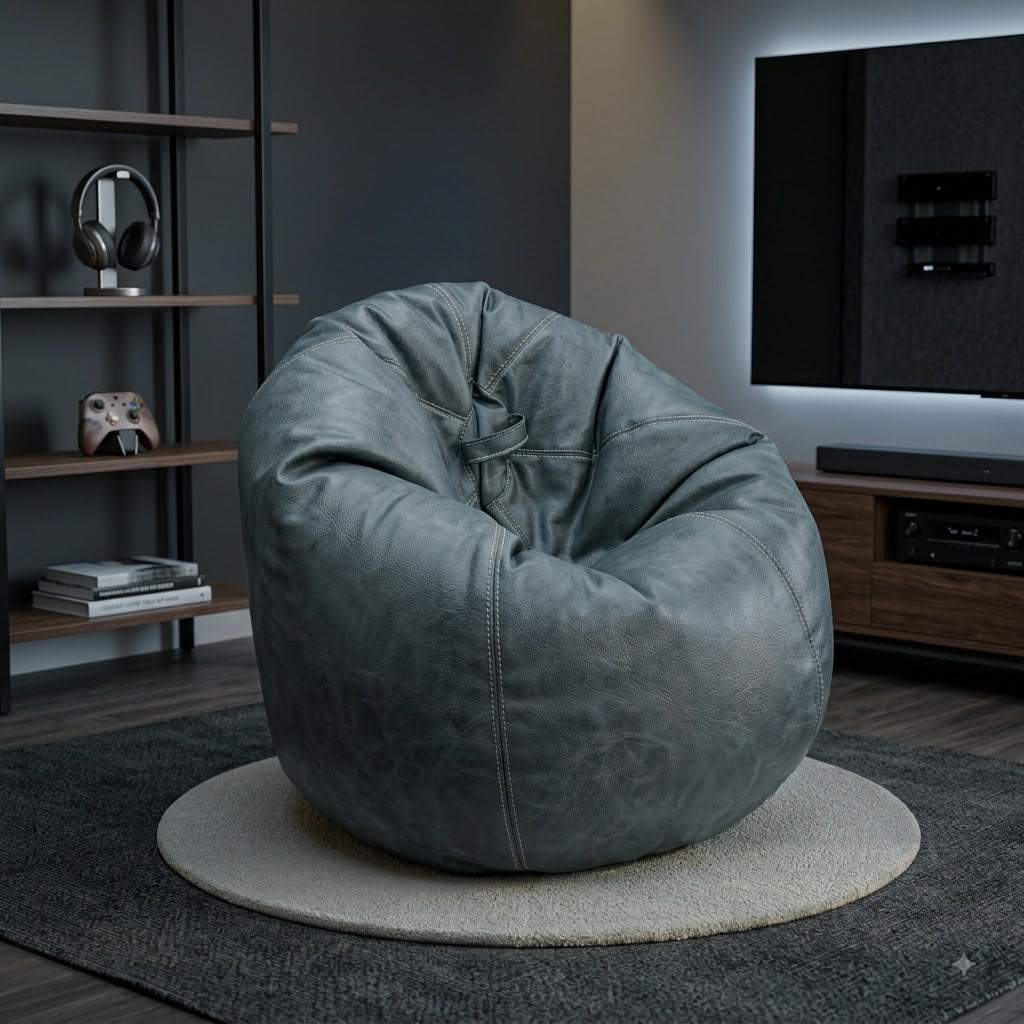A large, rounded gray faux-leather bean bag chair with a distressed texture, styled in a modern living room setting on a round rug.