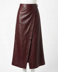 A dark burgundy leather midi skirt with a wrap-style front and a small belt buckle at the waist, displayed on a white mannequin against a plain white background.