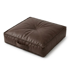 A square dark brown -leather floor cushion with a tufted top design and a side handle, shown on a plain white background.