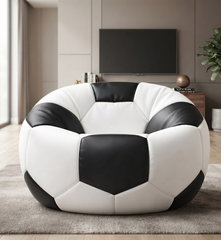 A soccer ball-shaped bean bag chair with a black and white paneled design, placed on a gray rug in a modern living room setting.